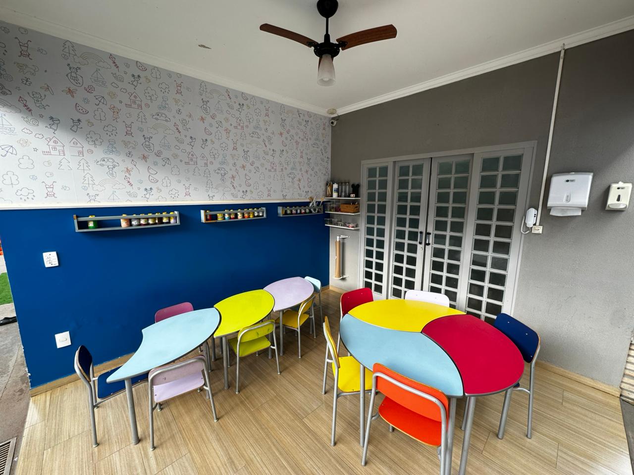 Sala de arte com mesas e cadeiras coloridas