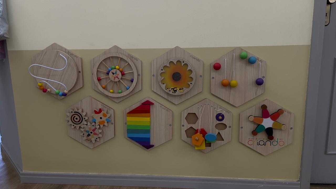 Painel sensorial com brinquedos de madeira